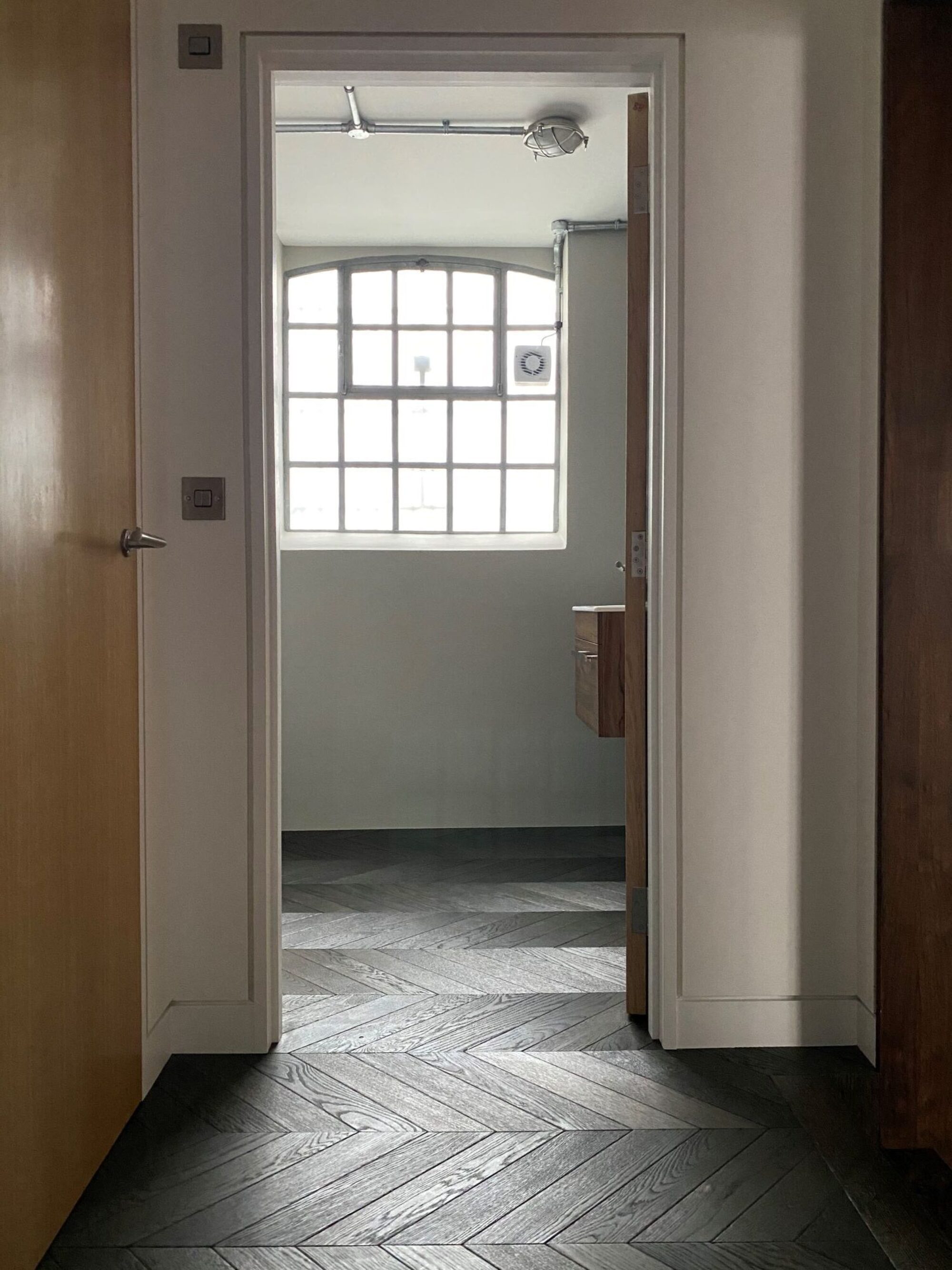 Black engineered chevron floor County Rutland in hallway and bathroom