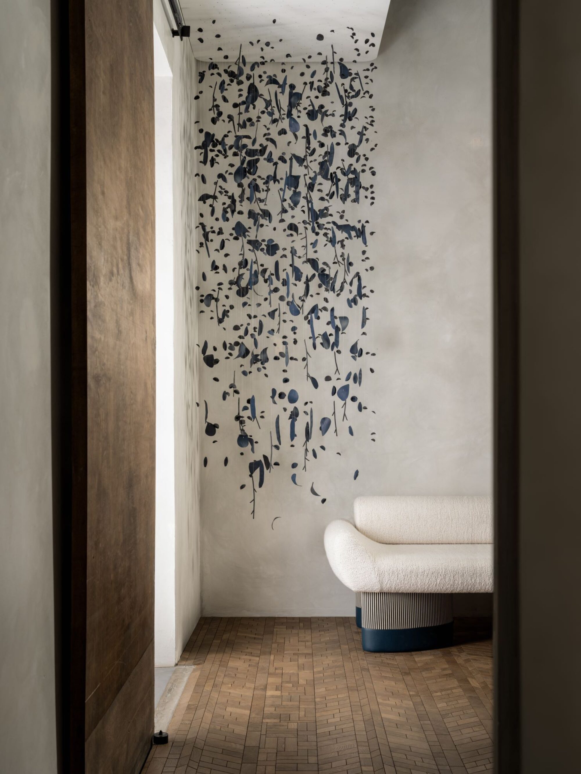 Interior with FORET smoke endgrain flooring, white walls and a large black mobile hanging from the ceiling at les atelier courbet, new york.
