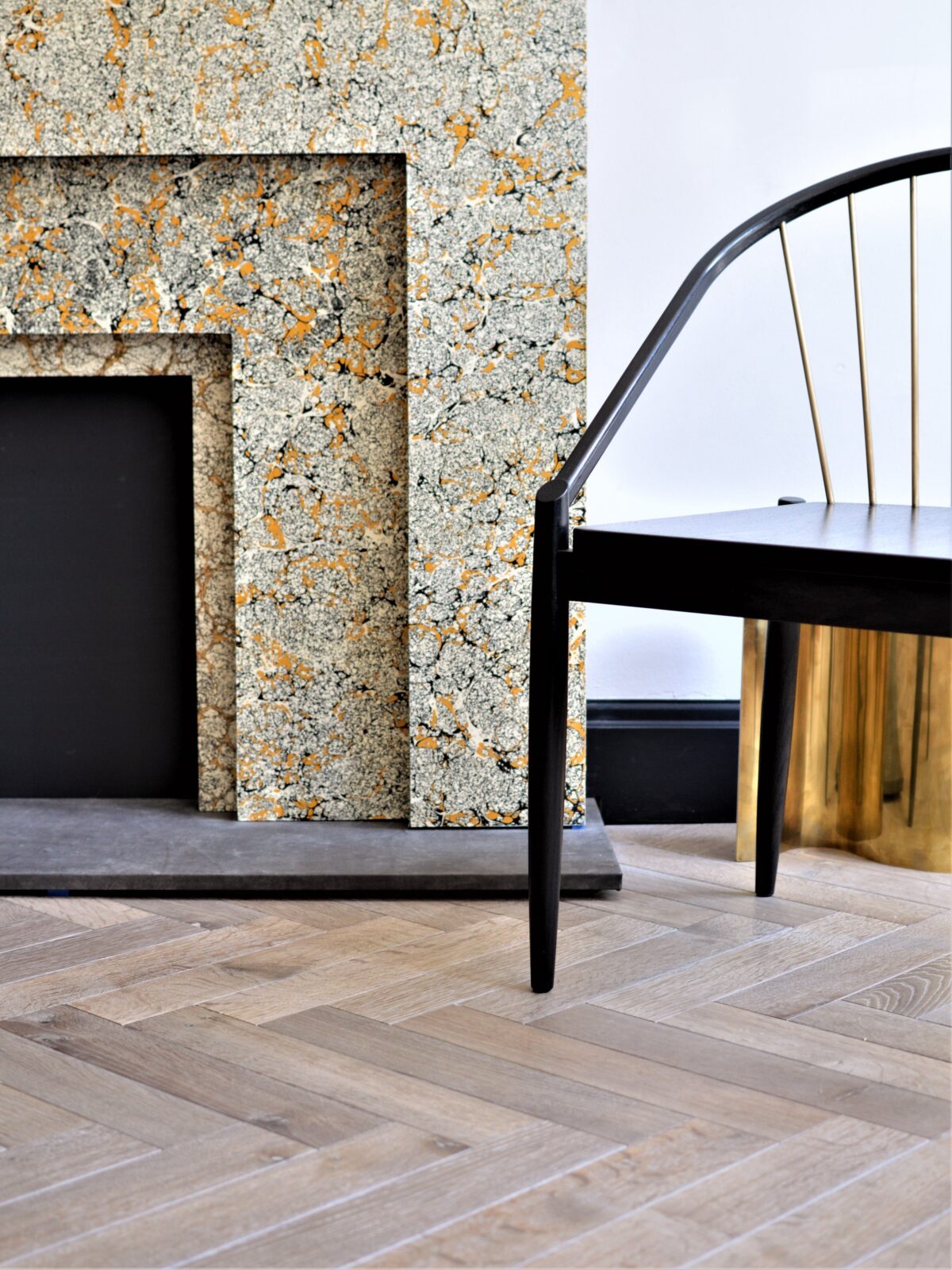 classic herringbone floor with fireplace & chair