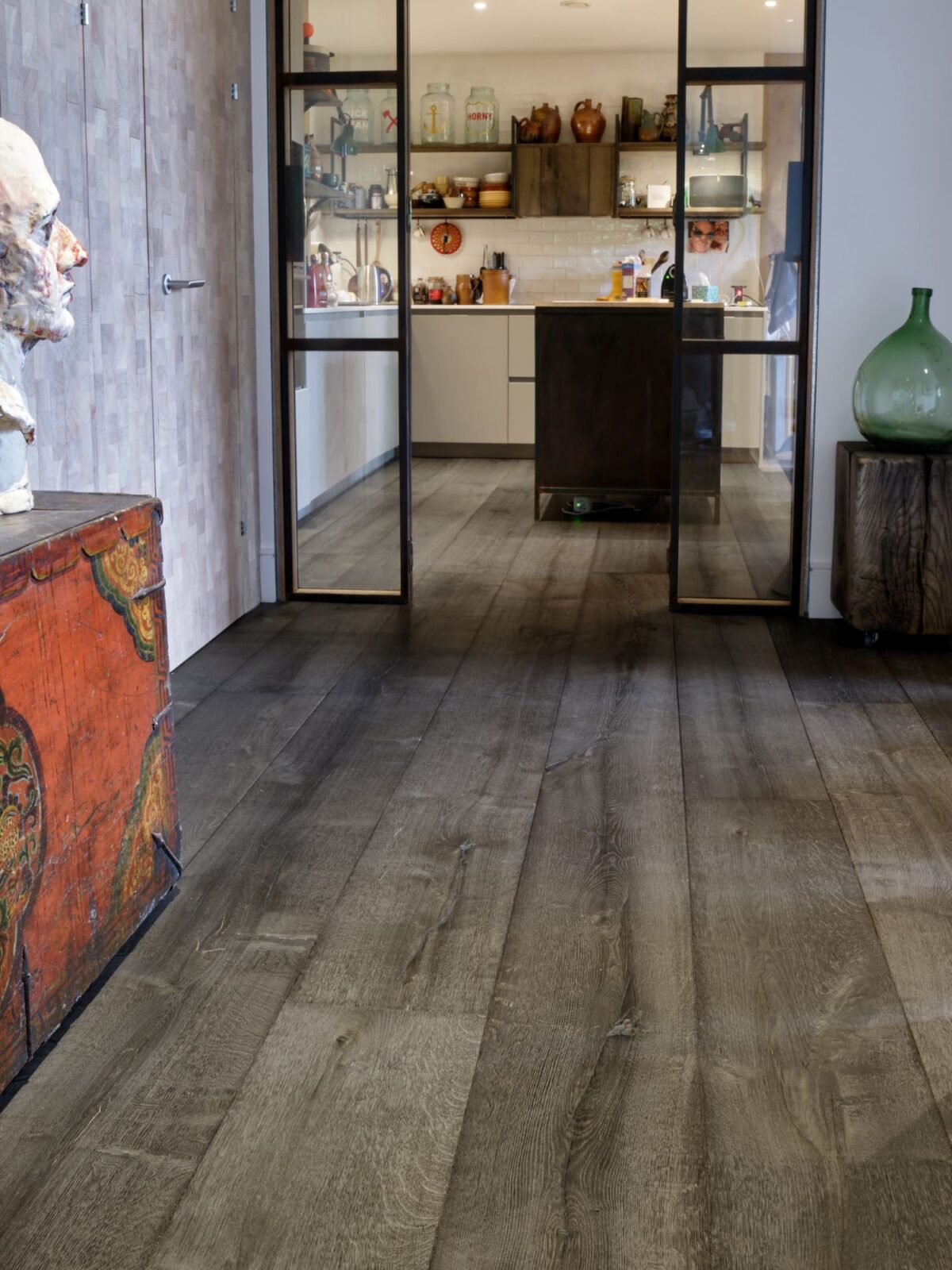 Magma mayon dark textured oak engineered flooring in hallway with kitchen in background and steel doors