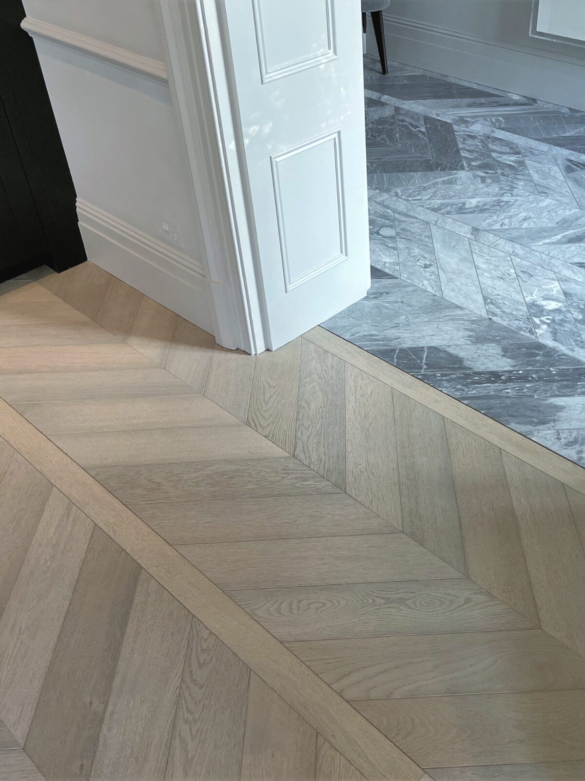 light chevron floor next to hallway marble fllor