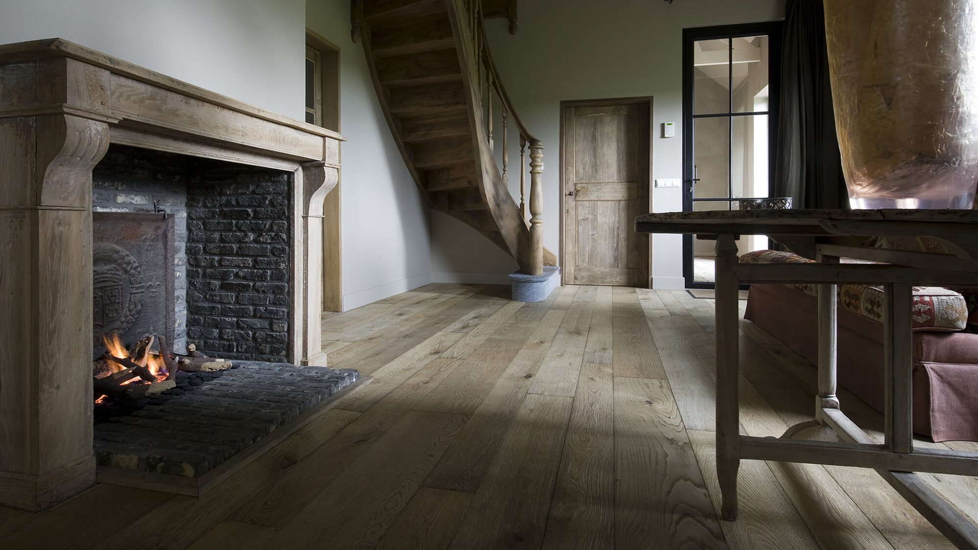 Magma Pacaya rustic floor in barn conversion with fireplace and curved staircase