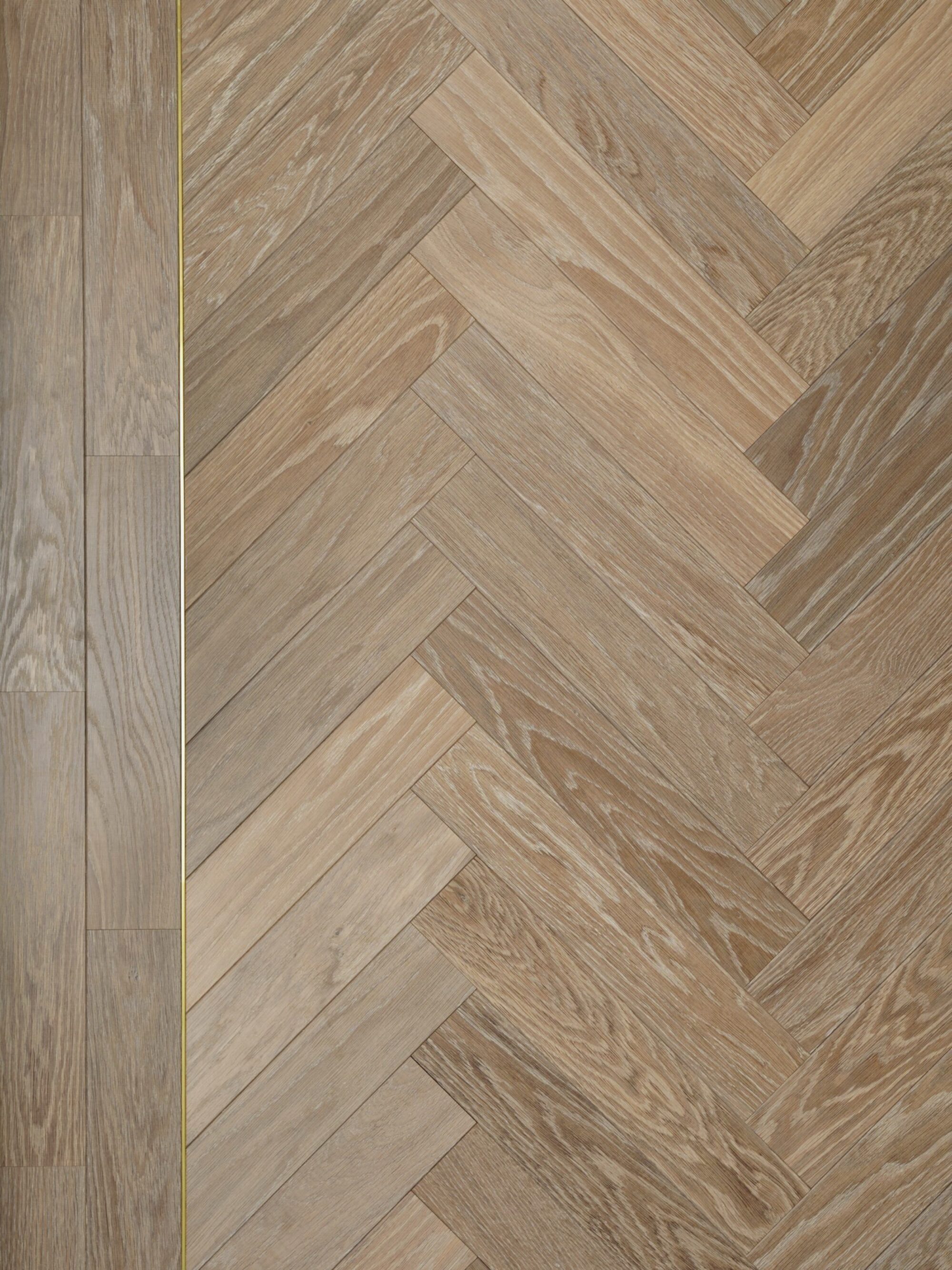 Modern neutral Landmark Dyrham oak herringbone parquet flooring with double border and brass inlay