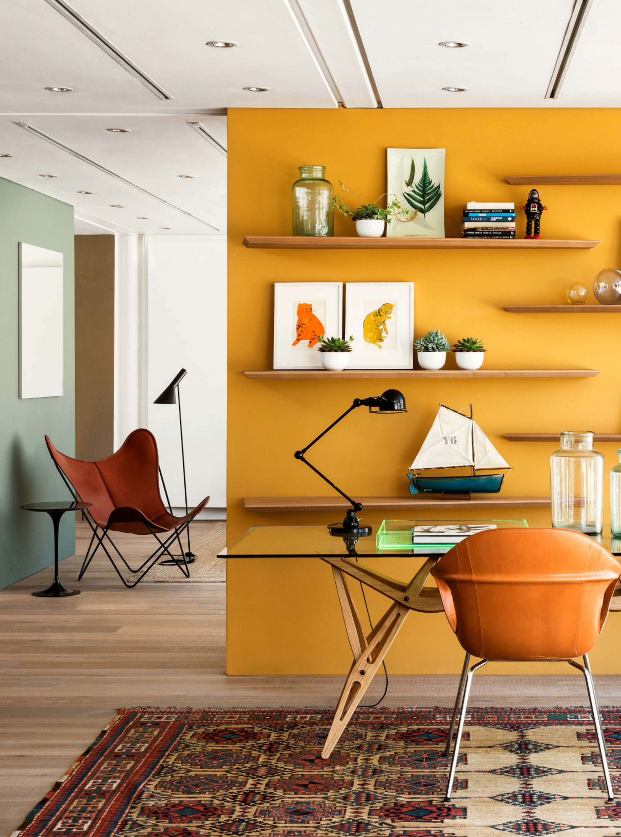 Oak tate skye plank in the conran store with open shelves on a yellow wall and a leather knoll butterfly chair