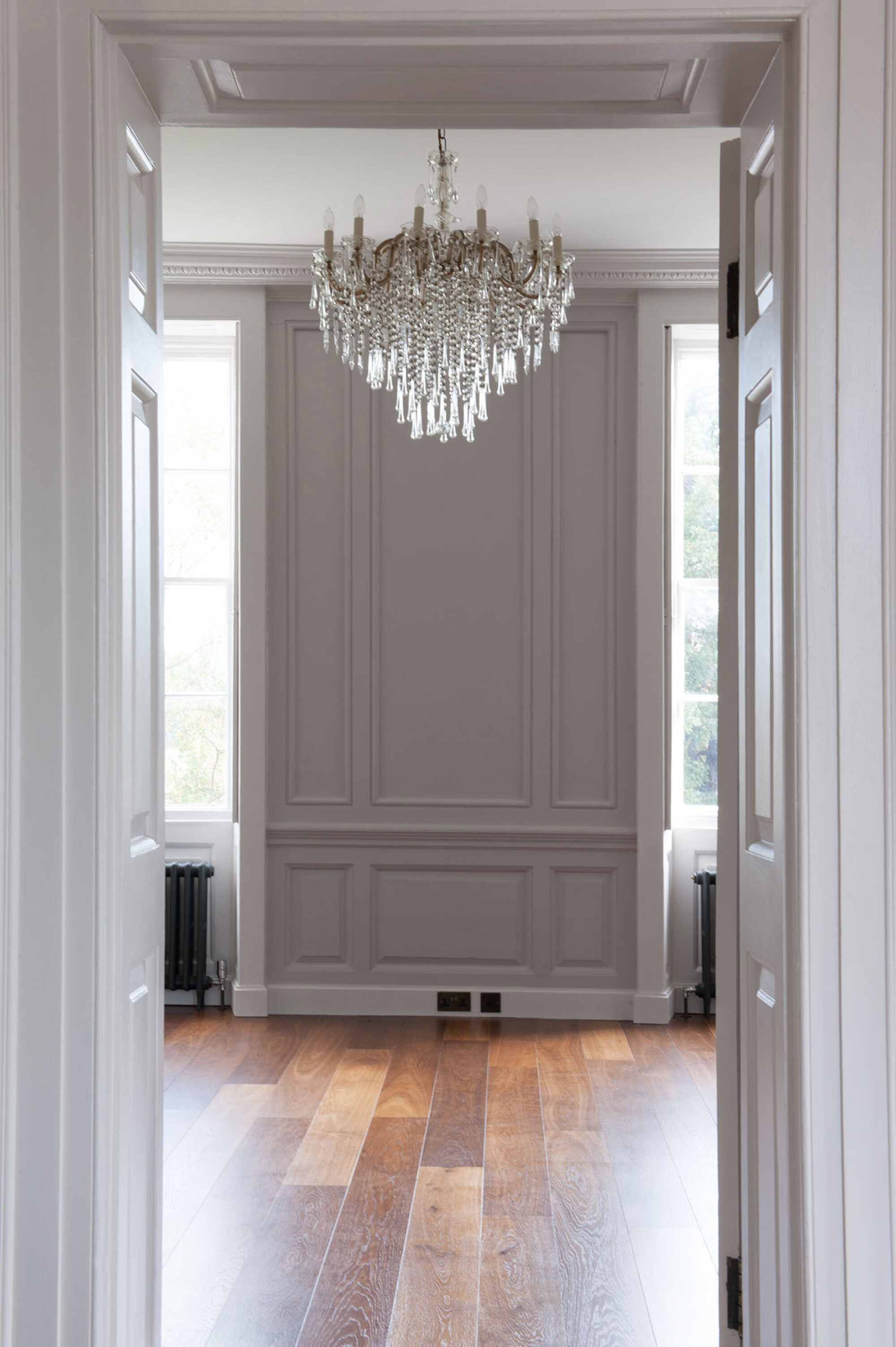 Oak landmark tatton planks through doorway with a crystal chandelier