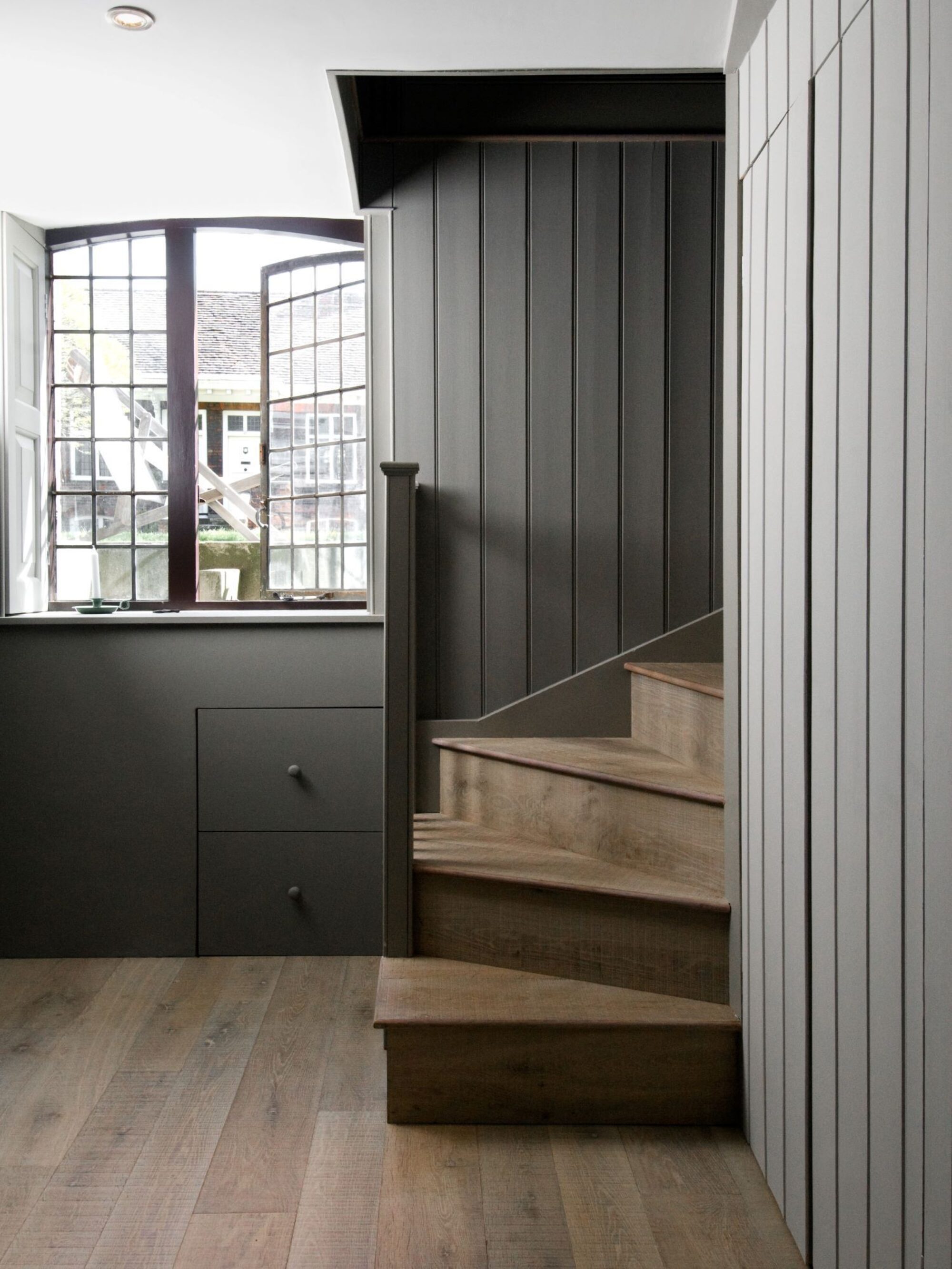 Tate bute flooring with timberclad staircase and grey paneling 1