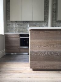 Oak tate bute on floor and kitchen fronts with marble tiles