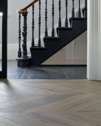Oak tate tiree chevron against floor tiles and a staircase