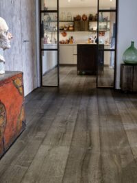 Magma mayon dark textured oak engineered flooring in hallway with kitchen in background and steel doors
